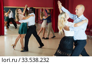 Positive adult couples dancing tango together in modern studio. Стоковое фото, фотограф Яков Филимонов / Фотобанк Лори