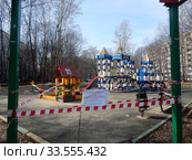 Огороженная полосатой лентой детская площадка во дворе жилых домов на Сахалинской улице в дни самоизоляции при коронавирусе Covid-19. Район Гольяново. Город Москва. Россия (2020 год). Редакционное фото, фотограф lana1501 / Фотобанк Лори
