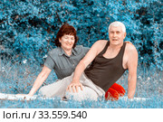 Mature beautiful couple in love on a green lawn in a park on a summer sunny day. Стоковое фото, фотограф Акиньшин Владимир / Фотобанк Лори