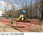 Огороженная полосатой лентой детская площадка во дворе жилых домов на Сахалинской улице в дни самоизоляции при коронавирусе Covid-19. Район Гольяново. Город Москва. Россия (2020 год). Стоковое фото, фотограф lana1501 / Фотобанк Лори