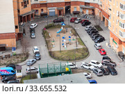 Empty precinct with parked cars and closed children playground of an apartment building. All people are staying at home during COVID-19 pandemic (2020 год). Редакционное фото, фотограф Кекяляйнен Андрей / Фотобанк Лори