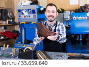 Positive male worker showing fixed shoes. Стоковое фото, фотограф Яков Филимонов / Фотобанк Лори