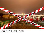 Coronavirus in Prague, Czech Republic. Embankment of the Vltava River near Charles Bridge. Quarantine sign on a blurred background. Concept of COVID pandemic and travel in Europe. (2019 год). Стоковое фото, фотограф Владимир Журавлев / Фотобанк Лори
