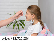 Выздоравливающей девочке дали очередное лекарство с ложечки. Стоковое фото, фотограф Иванов Алексей / Фотобанк Лори