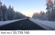 Автомобиль едет по заснеженной трассе Кола в Карелии (2020 год). Редакционное видео, видеограф Кекяляйнен Андрей / Фотобанк Лори