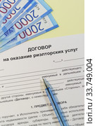 Договор на оказание риэлторских услуг,  ручка и деньги на желтом столе. Стоковое фото, фотограф Наталья Гармашева / Фотобанк Лори