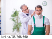 Young male contractor visiting old doctor. Стоковое фото, фотограф Elnur / Фотобанк Лори