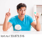 Man trying contact lenses at home. Стоковое фото, фотограф Elnur / Фотобанк Лори