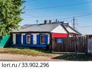 Barnaul, Russia - September, 22, 2019: Old one-story private house with wooden gates. Old autumn city. Shevchenko street. Редакционное фото, фотограф Вадим Орлов / Фотобанк Лори