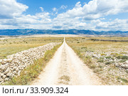 Dirt road leading trough dry rocky Mediterranean coastal lanscape of Pag island, Croatia in summertime. Стоковое фото, фотограф Matej Kastelic / Фотобанк Лори
