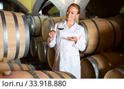 Female wine house worker checking quality of product. Стоковое фото, фотограф Яков Филимонов / Фотобанк Лори