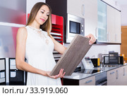 Positive woman looking for stylish kitchen fronts. Стоковое фото, фотограф Яков Филимонов / Фотобанк Лори