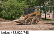 Skid steer loader moving sand soil at construction area outdoors. Редакционное видео, видеограф Сергей Старуш / Фотобанк Лори