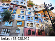 Hundertwasser house in Vienna, Austria. The Hundertwasserhaus apartment block has colorful facade, undulating floors, a roof covered with earth and grass, and large trees (2019 год). Редакционное фото, фотограф Nataliia Zhekova / Фотобанк Лори