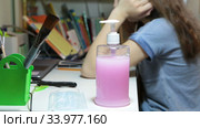 Liquid antiseptic gel and facial mask for pre-teen Caucasian girl distance studying at home. Стоковое видео, видеограф Кекяляйнен Андрей / Фотобанк Лори