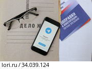 Приложение для смартфона Telegram Messenger на папке дело№ и буклетом поправок конституции 2020. Редакционное фото, фотограф Кузнецов Максим / Фотобанк Лори