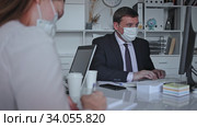 Man in protective medical mask helping his colleague to prepare document on your computer. Стоковое видео, видеограф Яков Филимонов / Фотобанк Лори