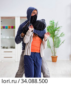Armed man assaulting young woman at home. Стоковое фото, фотограф Elnur / Фотобанк Лори