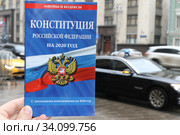 Брошюра конституции Российской Федерации на против дорогой правительственной машины с мигалкой у Государственной Думы (2020 год). Редакционное фото, фотограф Кузнецов Максим / Фотобанк Лори