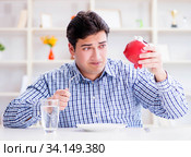 Man running out of money in restaurant and using savings from pi. Стоковое фото, фотограф Elnur / Фотобанк Лори