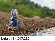 Игрушки. Вязаный крючком кот стоит с удочкой и ведром на берегу реки. Стоковое фото, фотограф Dmitry29 / Фотобанк Лори