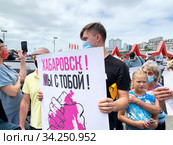 Владивосток, молодой мужчина держит плакат "Хабаровск! Мы с тобой" на митинге в поддержку протестующих в Хабаровске (2020 год). Редакционное фото, фотограф Овчинникова Ирина / Фотобанк Лори