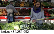 Female shopper picks leek at grocery store. Стоковое видео, видеограф Яков Филимонов / Фотобанк Лори