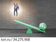 Businessman in tax concept with seesaw. Стоковое фото, фотограф Elnur / Фотобанк Лори