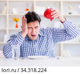 Man running out of money in restaurant and using savings from pi. Стоковое фото, фотограф Elnur / Фотобанк Лори