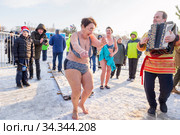 Russia Samara December 2019: holiday of walruses on the river. an elderly woman in a swimsuit dancing on ice before swimming in the ice hole on a winter day. Редакционное фото, фотограф Акиньшин Владимир / Фотобанк Лори