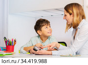 Teacher explain autistic boy lesson duration timer. Стоковое фото, фотограф Сергей Новиков / Фотобанк Лори