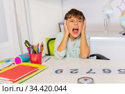 Screaming autistic boy close ears learning numbers. Стоковое фото, фотограф Сергей Новиков / Фотобанк Лори