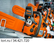 Ряд бензопил фирмы  Husqvarna лежат на витрине (2019 год). Редакционное фото, фотограф Вячеслав Палес / Фотобанк Лори