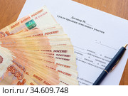 На договоре купли продажи земельного участка лежит пачка денег разложенных веером и ручка. Стоковое фото, фотограф Иванов Алексей / Фотобанк Лори