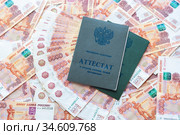 На пятитысячных российских купюрах лежат два аттестата о среднем полном общем образовании. Стоковое фото, фотограф Иванов Алексей / Фотобанк Лори