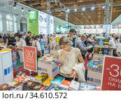 Посетители Московской международной книжной ярмарки выбирают книги на стенде "Читай город" (2020 год). Редакционное фото, фотограф Сайганов Александр / Фотобанк Лори