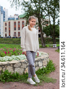 Full length portrait of pre-teen Caucasian girl wearing beige blouse and grey breeches stands outdoor, posing for camera. Стоковое фото, фотограф Кекяляйнен Андрей / Фотобанк Лори