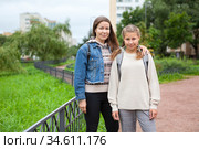 Pre-teen schoolgirl in grade 6 goes back to school at September with her mother, together portrait outdoor. Стоковое фото, фотограф Кекяляйнен Андрей / Фотобанк Лори
