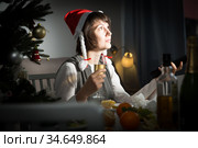 Bored woman watching Christmas tv program. Стоковое фото, фотограф Яков Филимонов / Фотобанк Лори