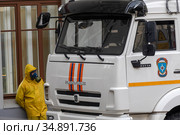 Сотрудник МЧС России в защитном костюме и противогазе во время процедуры дезинфекции Киевского вокзала в центре города Москвы во время пандемии коронавируса COVID-19 (2020 год). Редакционное фото, фотограф Николай Винокуров / Фотобанк Лори