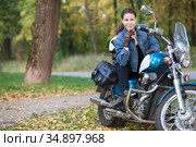 Beautiful woman in jeans jacket sitting on vintage motorbike in autumn park, copy space. Стоковое фото, фотограф Кекяляйнен Андрей / Фотобанк Лори