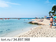 Ayia Napa, Cyprus-circa Sep, 2010: White sand and turquoise sea water are on the Nissi beach. It is a popular beach in the resort of Ayia Napa. The beach have small islet of Nissi. Редакционное фото, фотограф Кекяляйнен Андрей / Фотобанк Лори