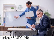 Yound and old employees in business presentation concept. Стоковое фото, фотограф Elnur / Фотобанк Лори