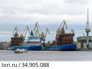 Судно на подводных крыльях (СПК) "Гермес" (тип "Метеор") проплывает по Неве мимо Балтийского завода и атомных ледоколов "Сибирь", "Арктика", "Урал". Санкт-Петербург (2020 год). Редакционное фото, фотограф Румянцева Наталия / Фотобанк Лори