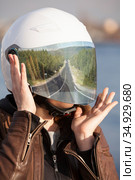 Long road reflection in mirrored tinted visor of helmet, portrait of unrecognizable European woman motorcyclist. Стоковое фото, фотограф Кекяляйнен Андрей / Фотобанк Лори