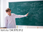 Schoolboy physicist in front of green board. Стоковое фото, фотограф Elnur / Фотобанк Лори