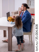 Girl bothering young father during working from house in pandemi. Стоковое фото, фотограф Elnur / Фотобанк Лори