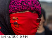Участник шествия коммунистов в красной защитной маске во время шествия, посвященного 103-й годовщине Октябрьской революции, на Красной площади в центре города Москвы, Россия (2020 год). Редакционное фото, фотограф Николай Винокуров / Фотобанк Лори