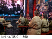 Женщины в одежде времен начала Великой Отечественной войны смотрят комедийный фильм "Свинарка и пастух" в импровизированном кинотеатре на Красной площади в центре города Москвы, Россия (2020 год). Редакционное фото, фотограф Николай Винокуров / Фотобанк Лори
