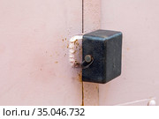 An iron padlock hangs on the doors of a metal street garage. Стоковое фото, фотограф Акиньшин Владимир / Фотобанк Лори